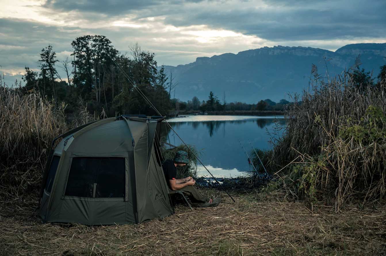 man in tent preparing for carp fishing