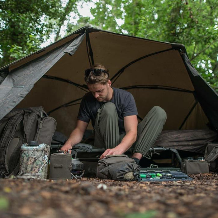 man inside tent getting ready for carp fishing